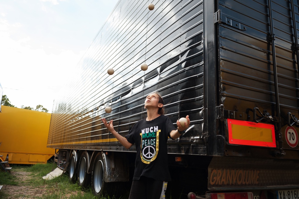 Manuel from “The Family Dem” is playing with juggling balls among the trucks.